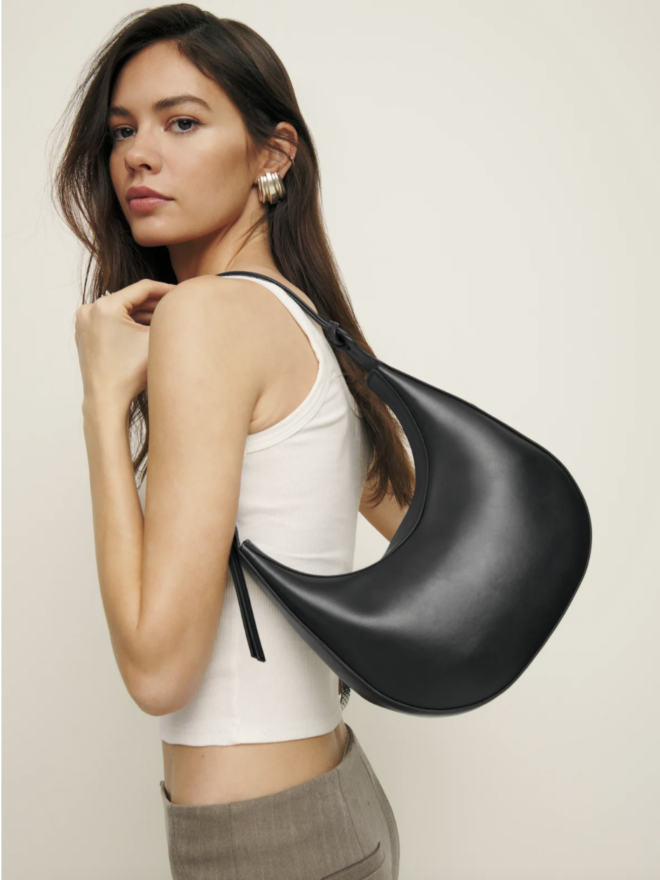 Medium Rosetta Shoulder Bag. Woman with bag over shoulder looking to camera